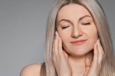 Gri arka planda güzel bir kadının portresi. Metin için boşluk