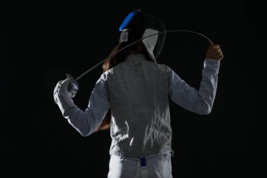 Siyah arka planda çişi olan bir eskrimci.