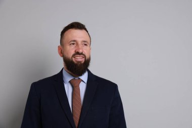 Gri arka planda takım elbiseli yakışıklı sakallı adam. Metin için boşluk
