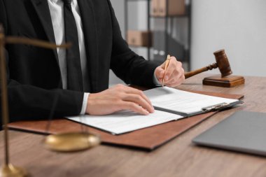 Ofisteki ahşap masada noter imzalı belge, yakın plan.