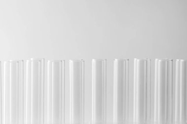 Işık arkaplanındaki boş test tüpleri, metin için boşluğa yakın çekim. Laboratuvar camları.