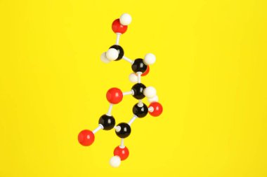 Sarı arka planda C vitamini molekülü. Kimyasal model
