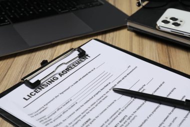 Anlaşma belgesi, kırtasiye, akıllı telefon ve dizüstü bilgisayar ahşap masaya, kapanış