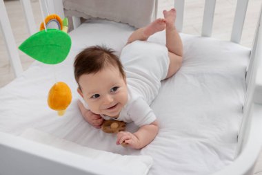 Evinde bebek karyolası olan küçük şirin bir bebek.