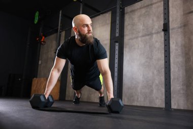 Sporcu spor salonunda halterli şınav çekerken, düşük açılı görüşte.