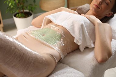 Vücut bakımı gören kadın spa salonunda tedavi görüyor.