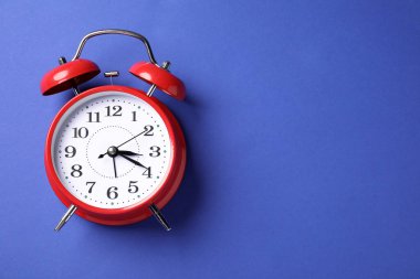 Mavi arka planda bir kırmızı alarm saati, üst manzara. Metin için boşluk
