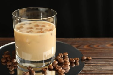 Bardakta kremalı kahve likörü ve ahşap masada fasulye, yakın plan. Metin için boşluk