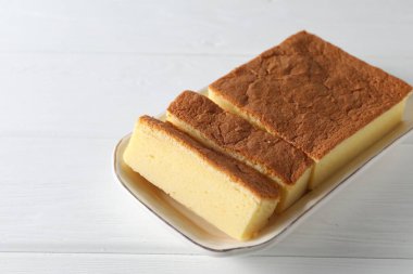 Lezzetli Japon Castella sünger keki beyaz ahşap masada, yakın plan. Metin için boşluk