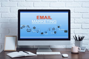 E- posta pazarlama web sitesi ekranda. Masasında bilgisayar olan işyeri