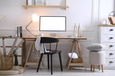 Evde rahat bir iş yeri. Odadaki boş beyaz ekranlı bilgisayar monitörü