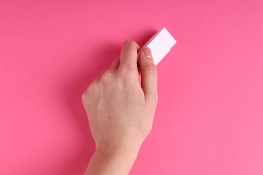 Pembe arka planda silgi kullanan kadın, yakın plan