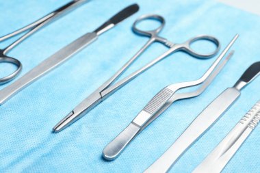 Açık mavi gazlı bezde farklı cerrahi aletler, yakın çekim.