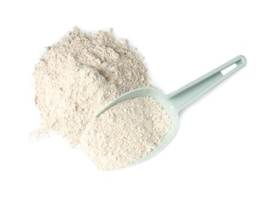 Pile of brown rice flour and scoop isolated on white, top view
