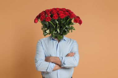 Turuncu arka planda kafası yerine çiçek buketi olan bir adam. Yaratıcı sanat kolajı