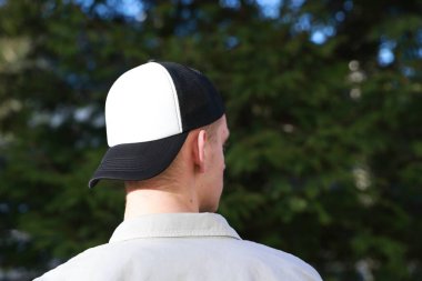 Beyzbol şapkalı bir adam dışarıda, arka manzaralı. Tasarım için model