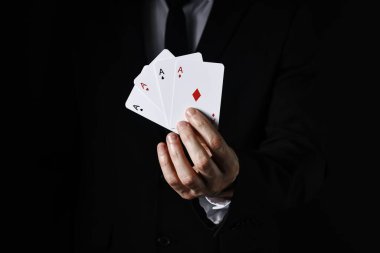 Siyah arkaplanda oyun kartları olan illüzyonist, yakın plan