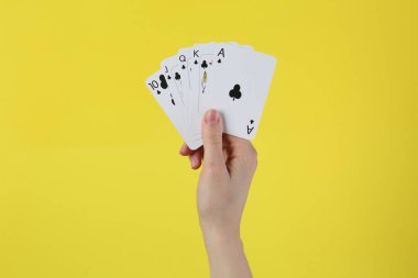 Sarı arka planda kart oynayan kadın, yakın plan