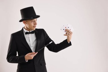 Sihirli değneği beyaz arka planda iskambil kağıdına doğrultan illüzyonist. Metin için boşluk