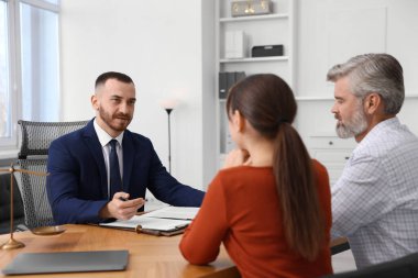 Ahşap masada profesyonel noterle görüşen çift.