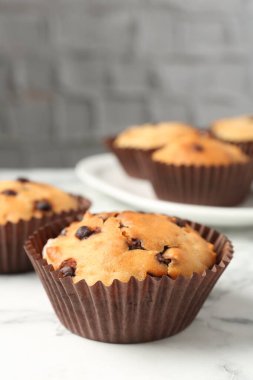 Beyaz mermer masa üzerinde çikolata parçalı lezzetli kek, yakın plan.