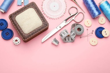 Pembe arka planda farklı dikiş malzemeleri var. Metin için boşluk