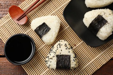 Pirinç topları (onigiri), soya sosu ve ahşap masa üzerindeki çubuklar, düz yatak. Geleneksel Japon yemeği