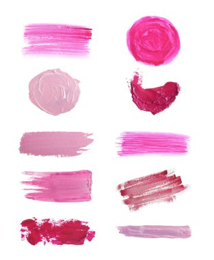Farklı boyaların fırça darbeleri pembe tonlarda, beyaz ve sette izole.