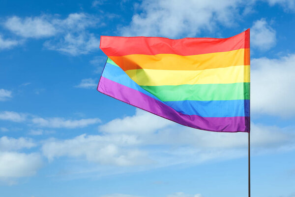 ЛГБТ-флаг, развевающийся над прекрасным голубым небом