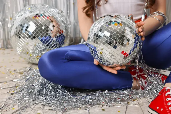 Eski moda elbiseli bir kadın ve yerde disko topları var, yakın plan.