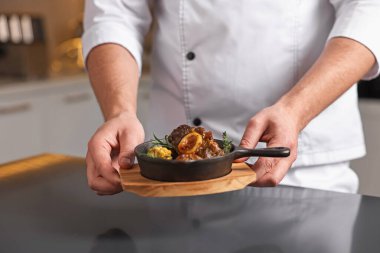 Masada servis yapan profesyonel şef, yakın plan.