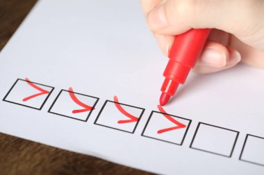 Ahşap masada kağıt kutusunu işaretleyen kadın, yakın plan.