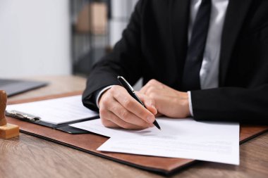 Ofisteki ahşap masada noter imzalı belge, yakın plan.