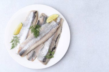 Limonlu ve dereotlu salamura ringa fileto, gri masa, üst manzara. Metin için boşluk