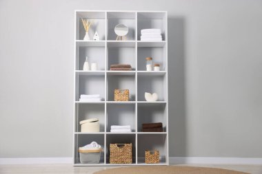 Açık gri duvarın yanında dekorlu raf ünitesi