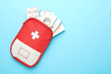 Açık mavi arka planda ilk yardım çantası, üst manzara. Metin için boşluk