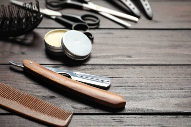 Many different barber's tools on wooden table, closeup. Space for text
