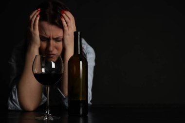 Alkol bağımlılığı. Masasında şarap olan sefil bir kadın. Metin için boşluk