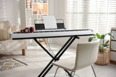 Müzik kâğıdı, kulaklık ve sandalyeli sentezleyici.
