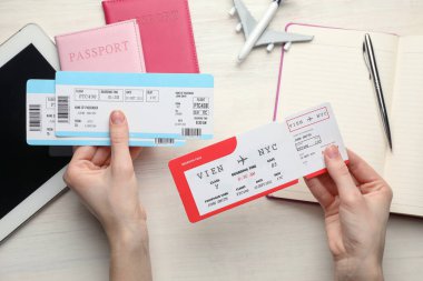 Seyahat acentesi. Hafif ahşap masada uçak bileti olan bir kadın.