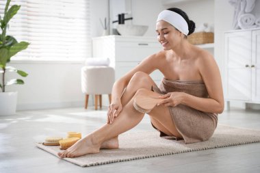 Kadın içeride fırçayla selülit masajı yapıyor. Metin için boşluk