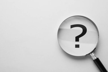 Işık arkaplanındaki soru işareti, büyüteçten üst görüntü. Metin için boşluk