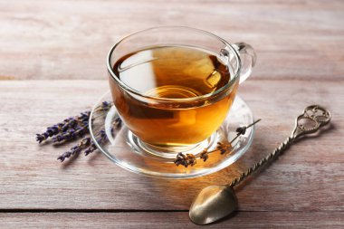 Cam bardakta Aromatik lavanta çayı, tahta masada kaşık ve kuru çiçekler, yakın plan