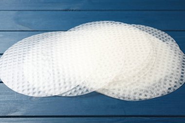 Mavi ahşap masadaki yenilebilir pirinç kağıtları, yakın plan.