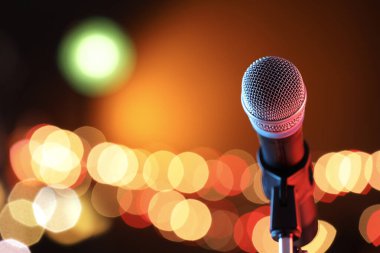 Mikrofon renk arkaplanına karşı, bulanık ışıklarla, metin için boşluk. Bokeh etkisi