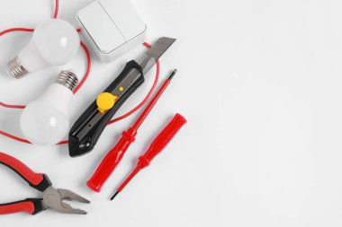Different electrical tools on light background, flat lay. Space for text