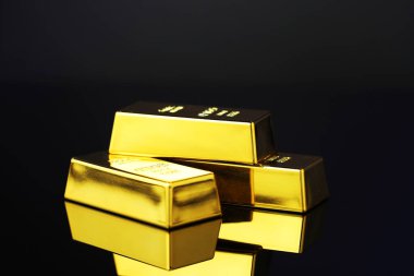 Koyu ayna yüzeyindeki altın çubuklar, yakın plan.