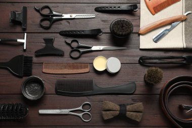 Birçok farklı berber aletleri ahşap masada, düz yatıyordu.