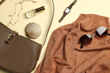 Şık kadın kıyafetleri ve bej arka planda farklı aksesuarlar.