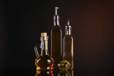 Aynanın yüzeyinde salata sosları ve zeytinler koyu arka planda.